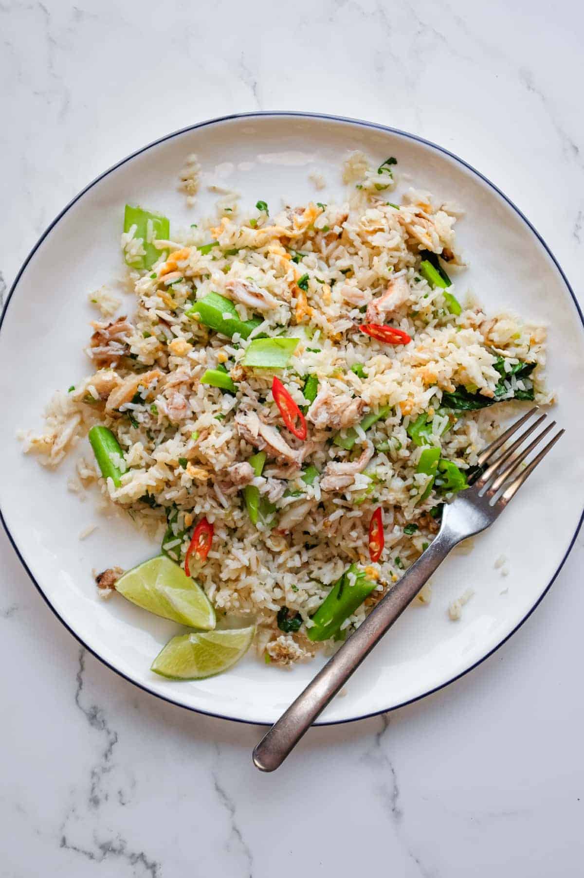 Overhead view of Vietnamese crab fried rice served with fresh lime wedges