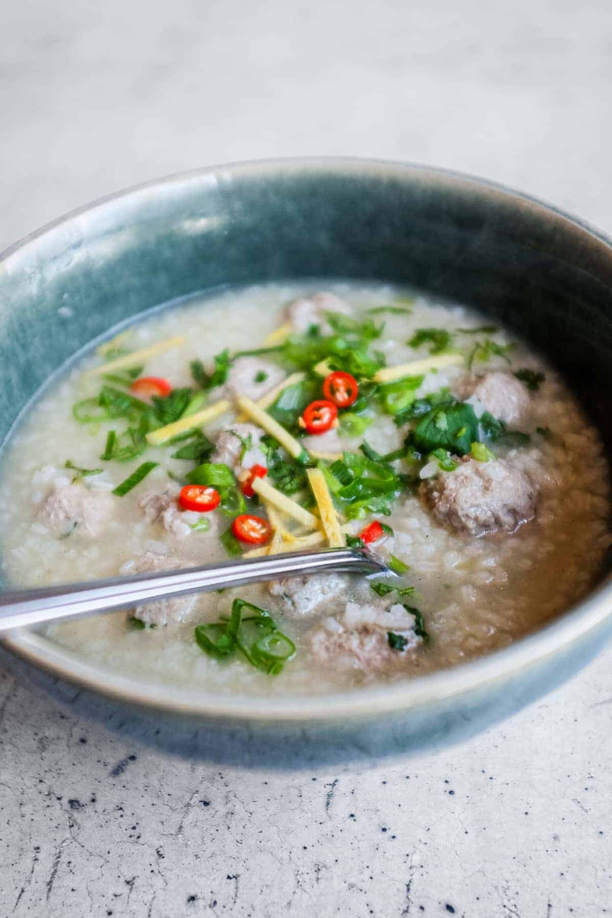 Khao tom moo Thai rice soup topped with fresh coriander, spring onion, chillies and julienned ginger