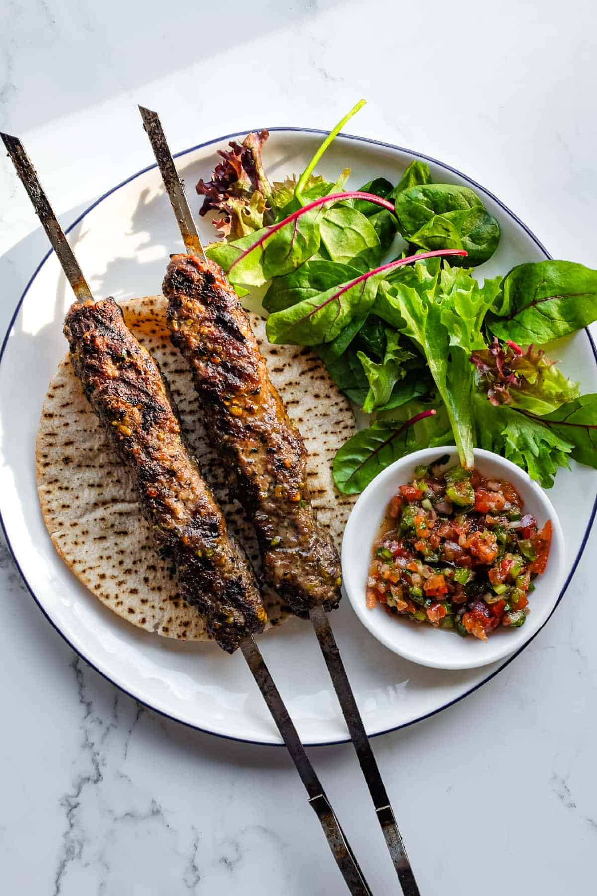 Traditional Turkish lamb kebabs inspired by Gaziantep with fresh salad accompaniments.