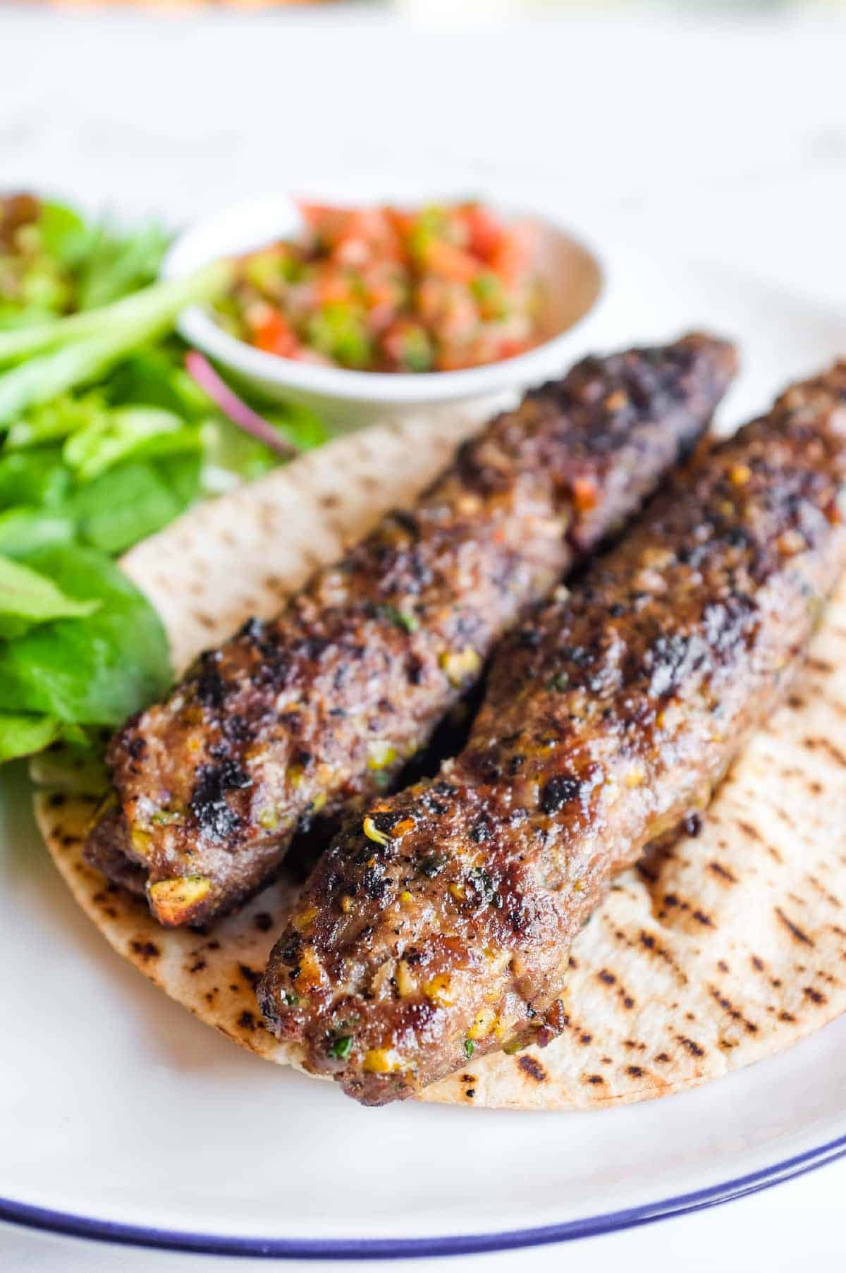Homemade Turkish lamb and pistachio kebabs served with a crisp green salad and spoon salad.