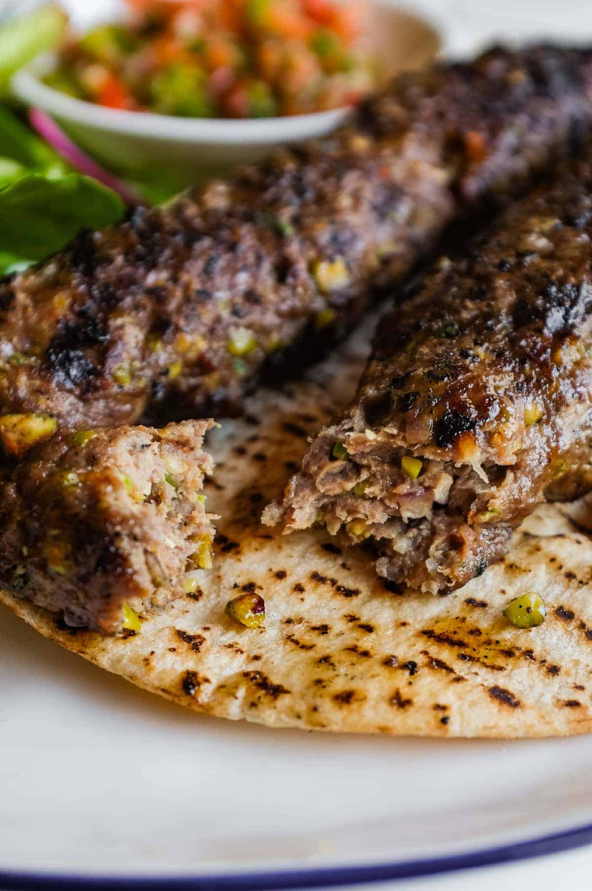 Antep Kebabı with juicy grilled lamb, pistachios, fresh herbs and vibrant Turkish salads.
