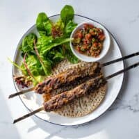 Tender Turkish lamb kebabs with pistachios served alongside a colourful spoon salad.