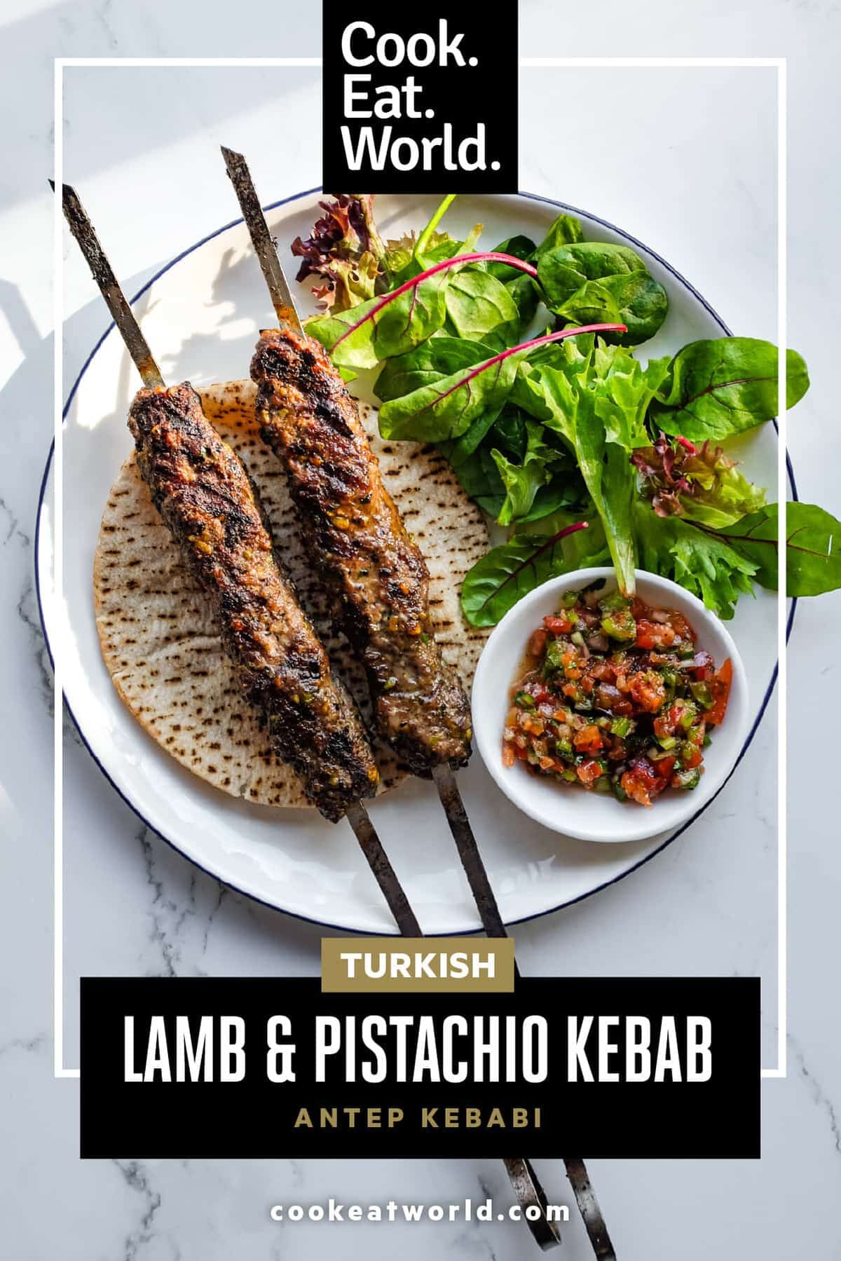 Chargrilled Antep Kebabı made with lamb and pistachios on a serving platter with Turkish salads.