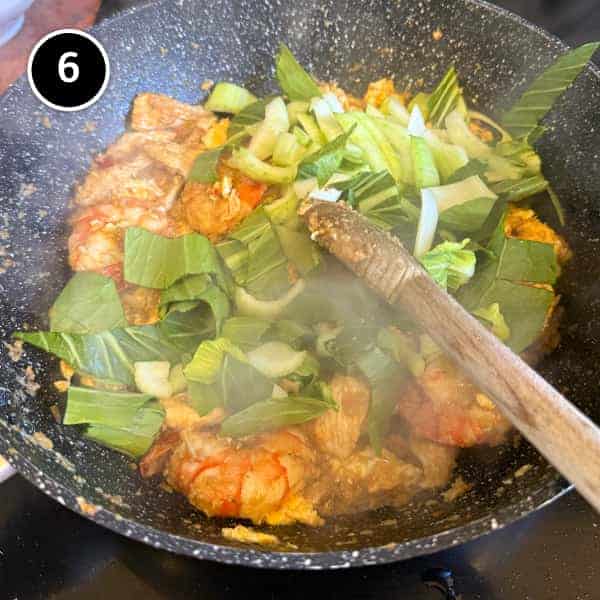Nasi Goreng Kampung (Malaysian Fried Rice) | cookeatworld.com Greens being added to a nasi goreng kampung spice paste with chicken and prawns