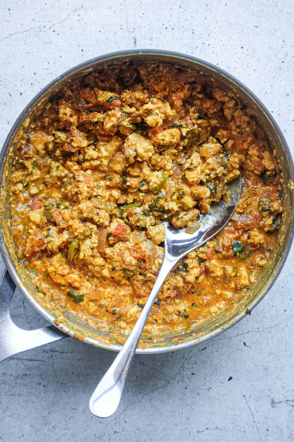 A pan of authentic Paneer Bhurji made with crumbled paneer, tomatoes and Indian spices.
