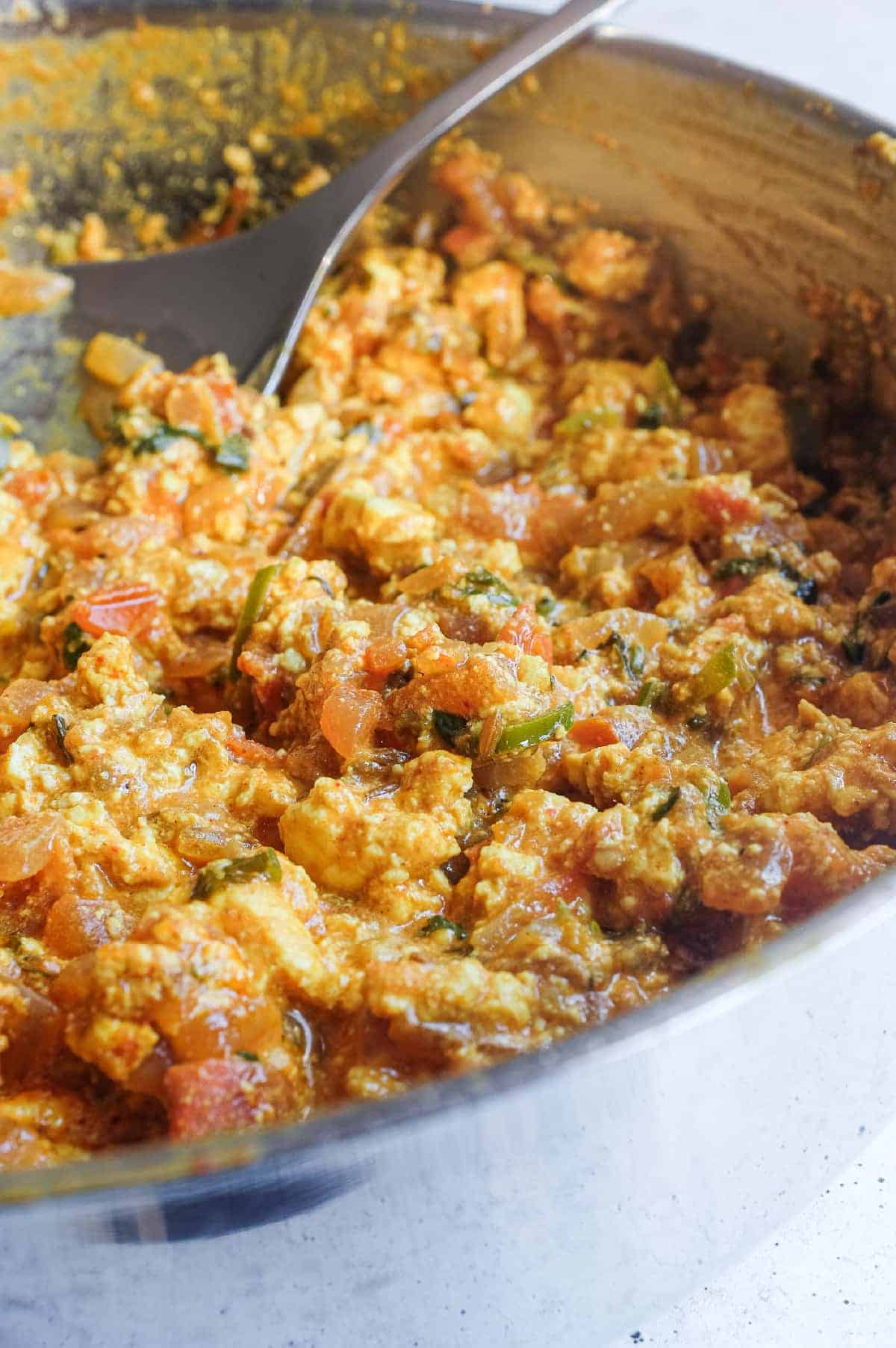Fragrant North Indian Paneer Bhurji cooking in a pan with herbs and spices.