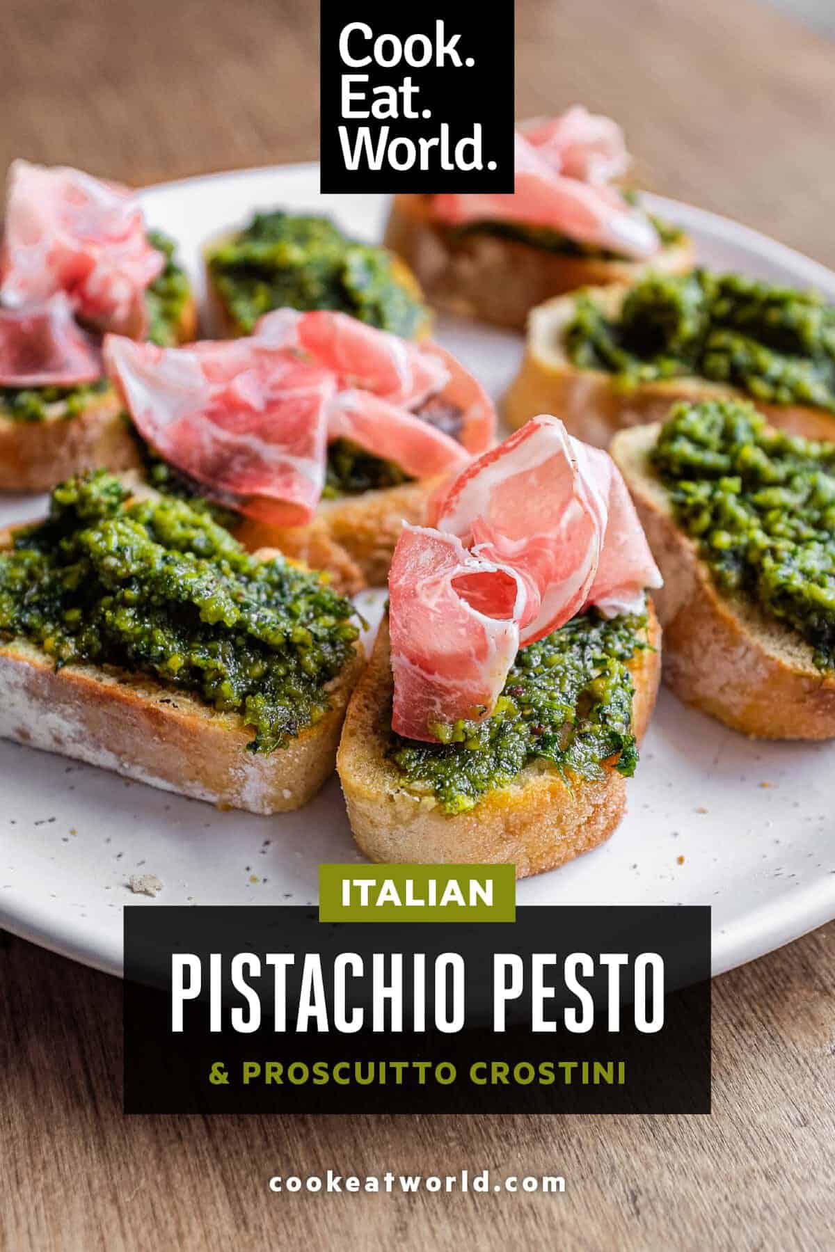 Sicilian pistachio pesto spread over toasted crostini with a selection of plain and prosciutto-topped pieces.