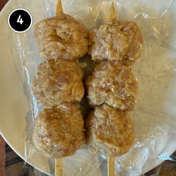 Tsukune (Japanese Chicken Meatballs) | cookeatworld.com Three uncooked tsukune meatballs threaded onto each short skewer
