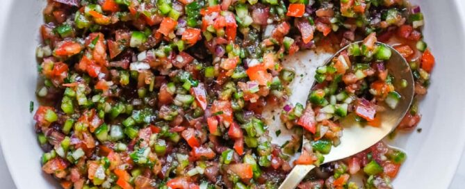 A bowl of authentic Turkish Spoon Salad with finely diced tomatoes, cucumber, onion and parsley in a tangy pomegranate dressing.
