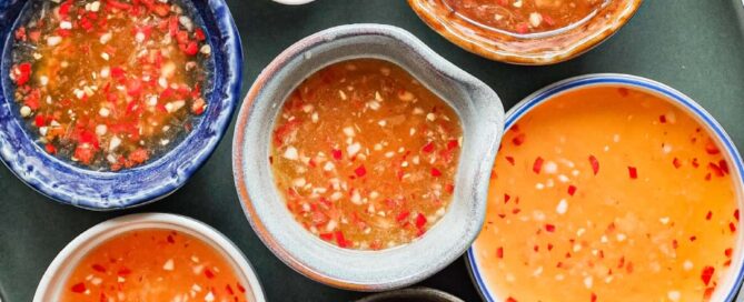 Homemade nuoc cham Vietnamese dipping sauce with chopped red chilli in a selctions of beautiful small bowls