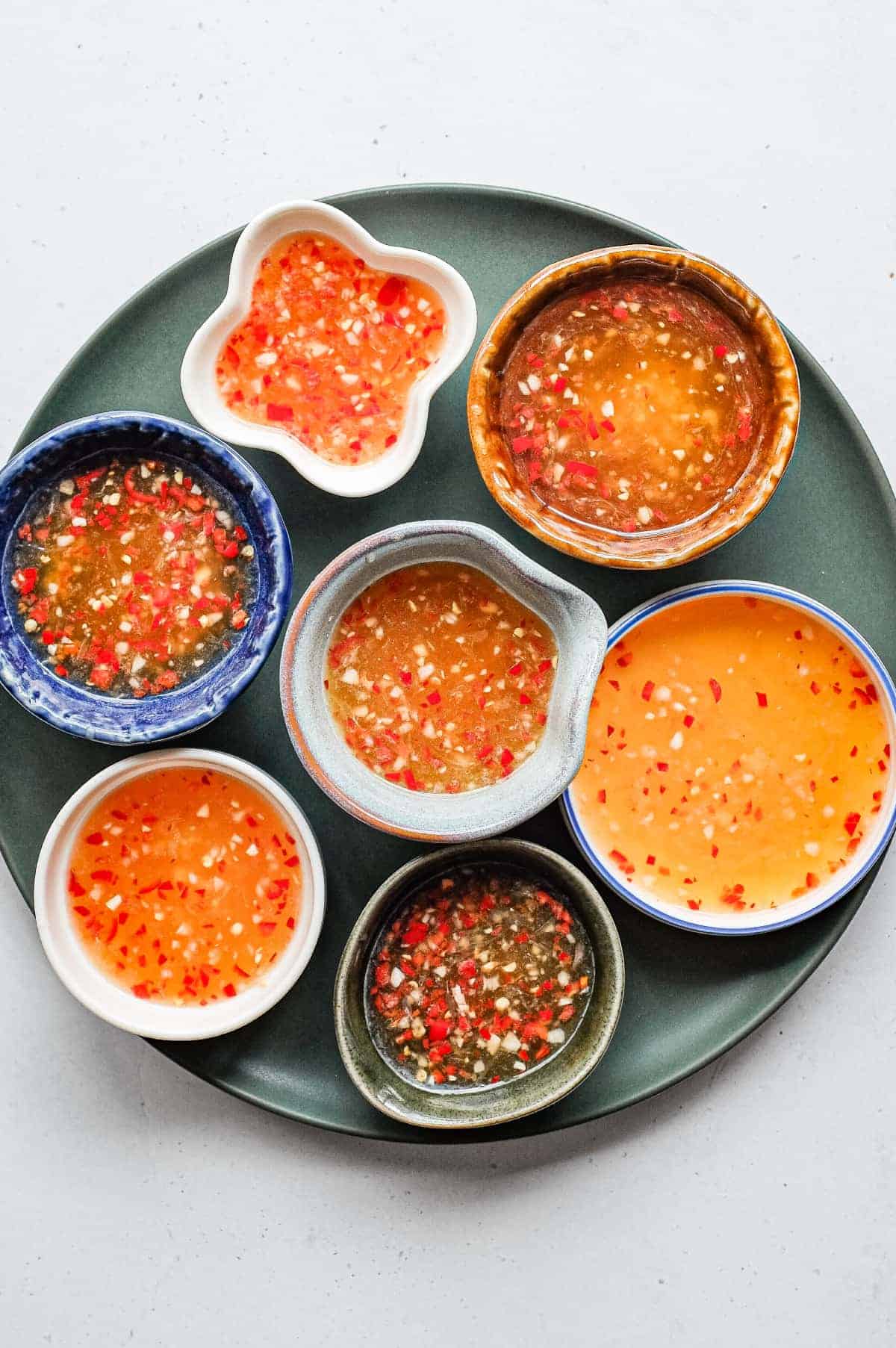 Homemade nuoc cham Vietnamese dipping sauce with chopped red chilli in a selctions of beautiful small bowls