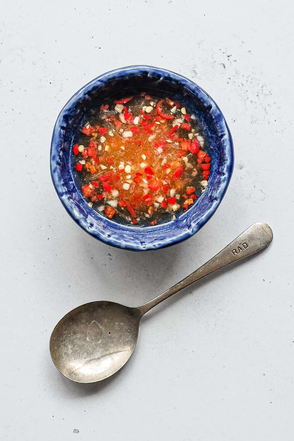 Bowl of nuoc cham with garlic, chilli and fresh lime
