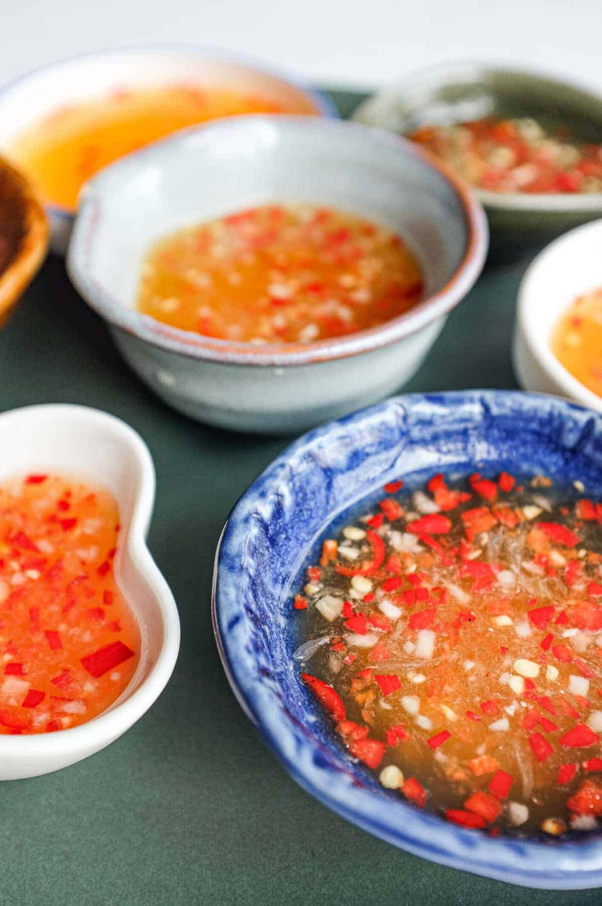 Vietnamese nuoc cham dipping sauce served in a selection of small ceramic bowls