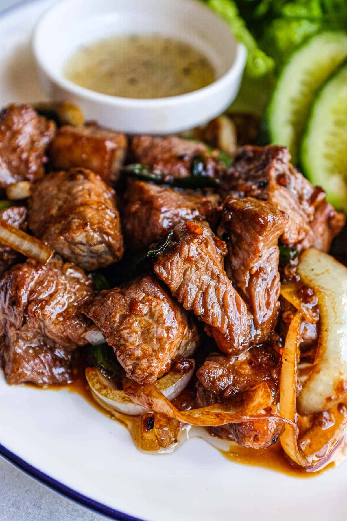 Close-up of Bò Lúc Lắc with caramelised beef and sliced green onions