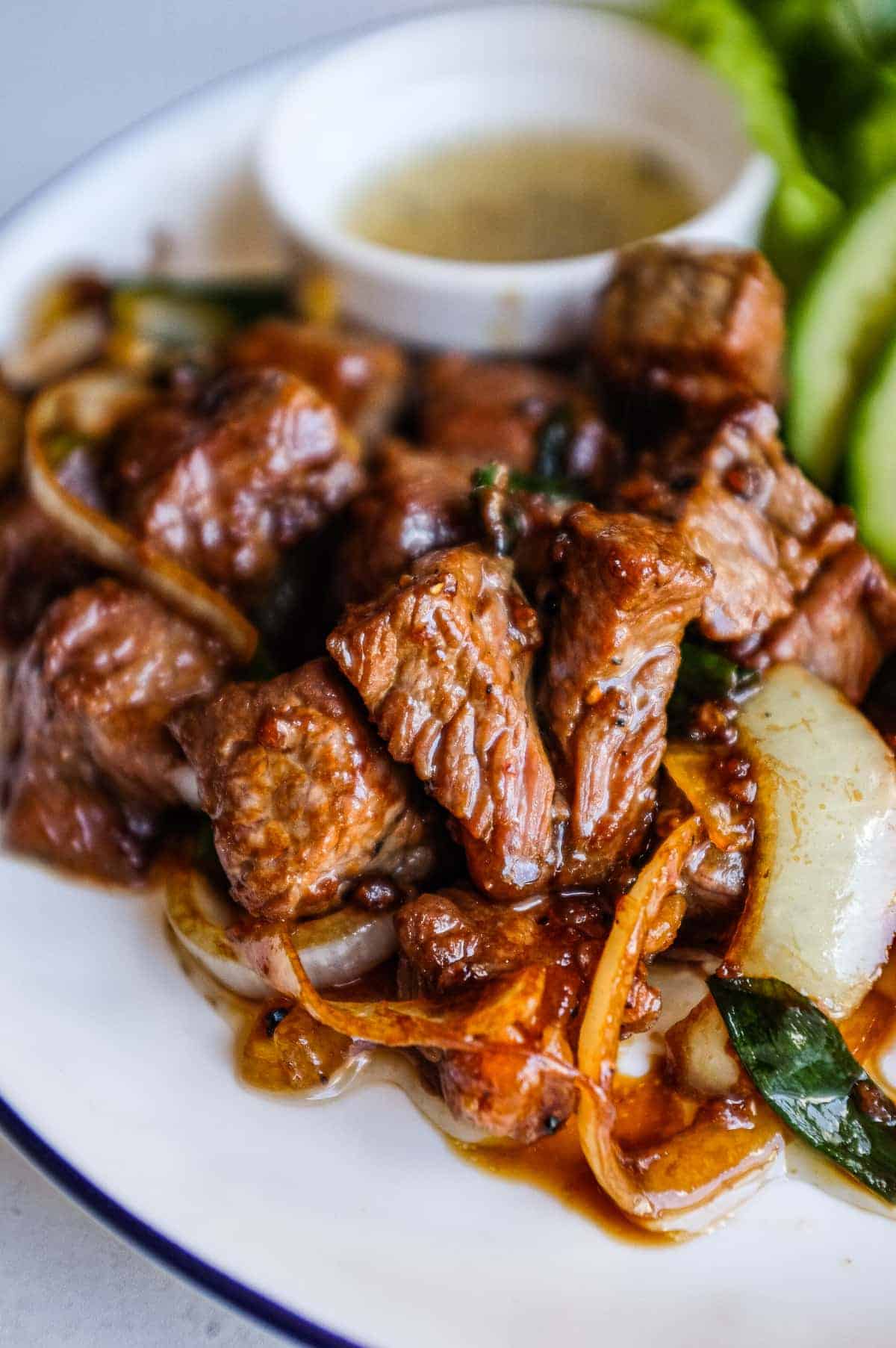 Ingredients for Vietnamese shaking beef arranged beside fresh salad vegetables