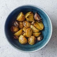 Italian roast potatoes with rosemary and garlic served in a bowl.