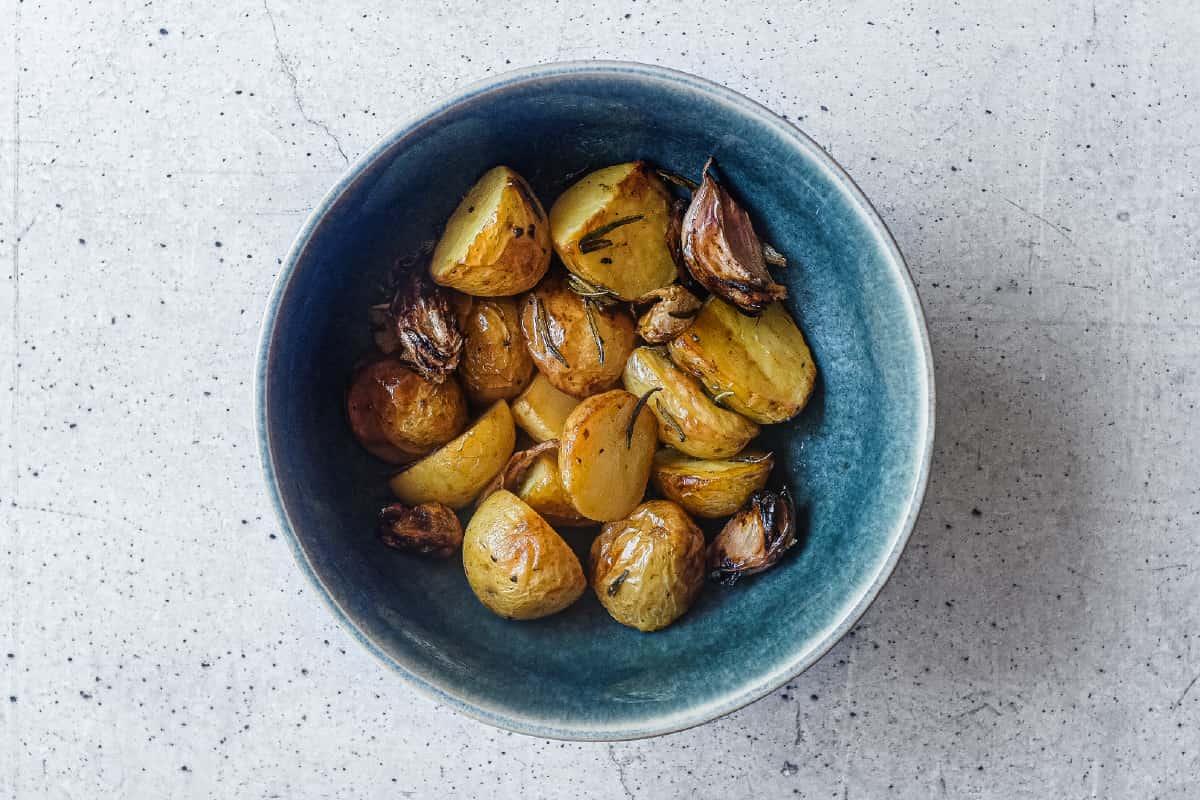 Italian roast potatoes with rosemary and garlic served in a bowl.