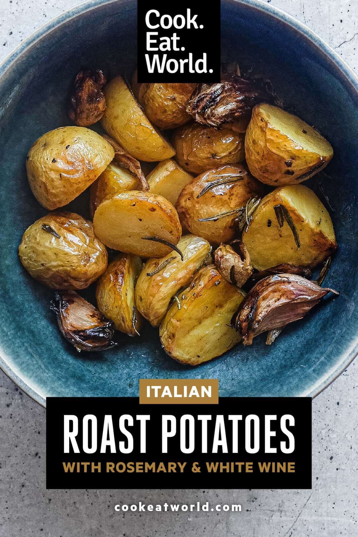 Bowl of golden patate al forno garnished with fresh rosemary.