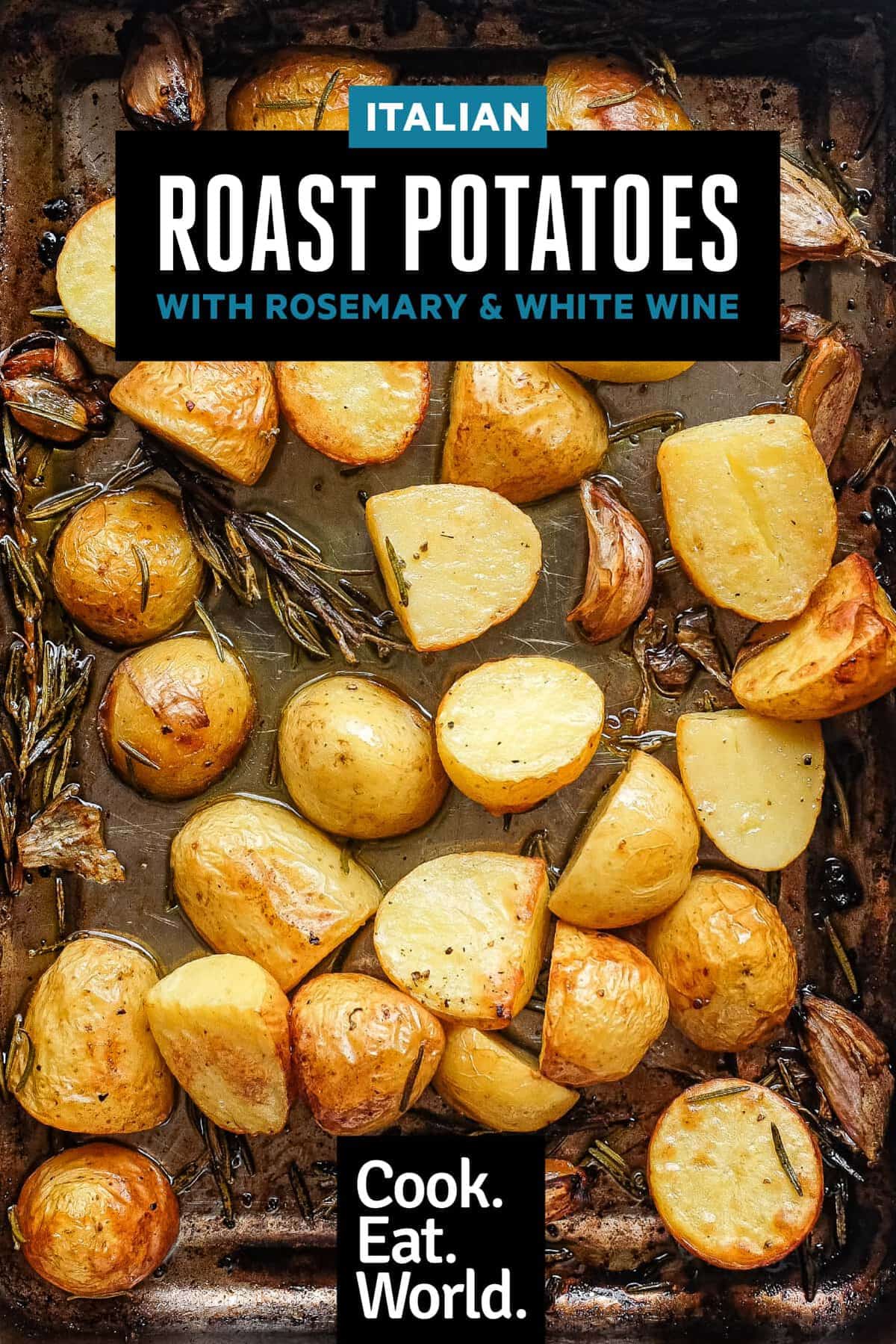 Golden Italian roast potatoes with fresh rosemary and garlic cloves in a roasting tin.